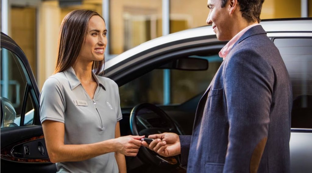 Lincoln valet attendant Olivia handing car keys to customer