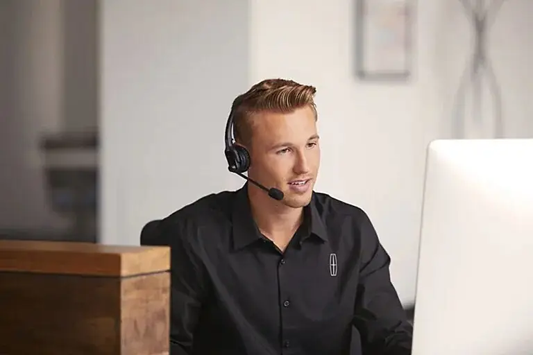 Lincoln customer service representative wearing headset at computer desk